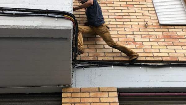 Imagen de uno de los jóvenes, encaramado a una fachada durante su huida Imagen de uno de los jóvenes, encaramado a una fachada durante su huida