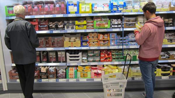 Consumidores llenando la cesta de la compra con alimentos. Consumidores llenando la cesta de la compra con alimentos.