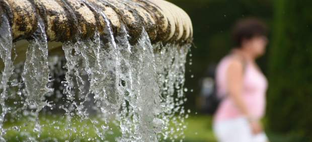Una mujer pasea cerca de una fuente