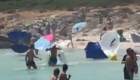 Un remolino se lleva sombrillas en una playa de Menorca
