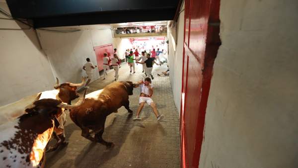 Corredor enganchado por el pañuelo en el encierro de Miura en Sanfermines. Corredor enganchado por el pañuelo en el encierro de Miura en Sanfermines.