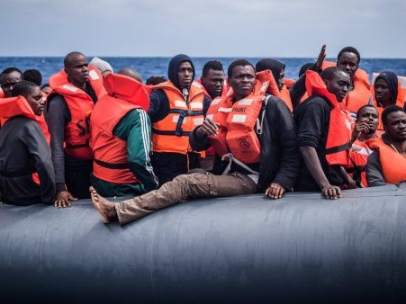 Refugiados en una lancha esperan a ser rescatados por miembros de la ONG SOS Méditerranée