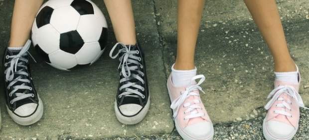 Dos niñas con un balón de fútbol.