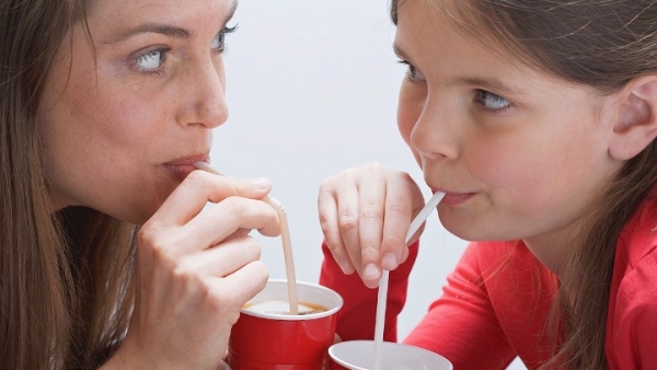 Madre e hija bebiendo con pajitas Madre e hija bebiendo con pajitas