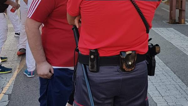 Agente de Policía Foral atendiendo a un ciudadano en fiestas de Tudela Agente de Policía Foral atendiendo a un ciudadano en fiestas de Tudela