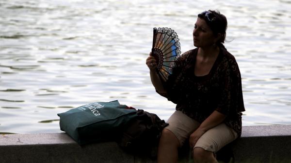 Una mujer se abanica por el calor Una mujer se abanica por el calor