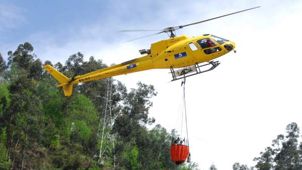 Un helicóptero, en labores para extinguir un incendio forestal Un helicóptero, en labores para extinguir un incendio forestal