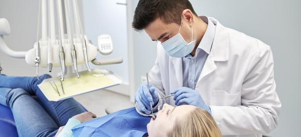 Un dentista atiende a una paciente.