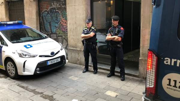 Dos agentes de la Guàrdia Urbana de Barcelona custodian un piso del Raval. Dos agentes de la Guàrdia Urbana de Barcelona custodian un piso del Raval.