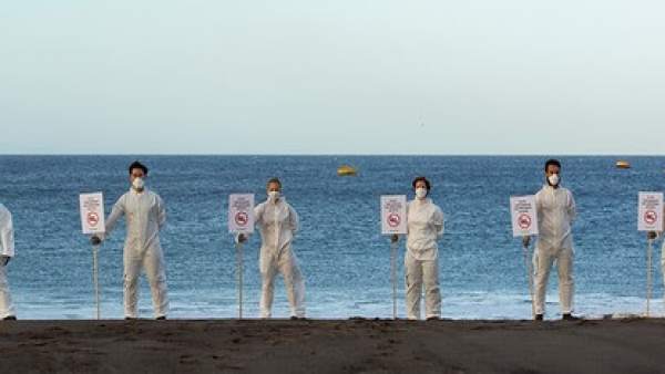 Activistas de Greenpeace cerrando simbólicamente una playa Activistas de Greenpeace cerrando simbólicamente una playa