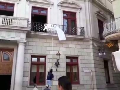 Ciudadanos retira una pancarta independentista en el Ayuntamiento de Reus.