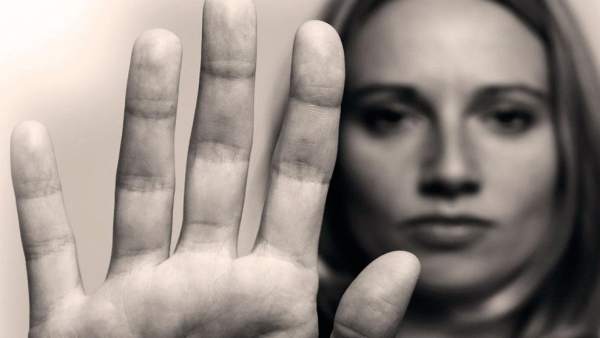 Una mujer levanta su mano en señal de stop Una mujer levanta su mano en señal de stop
