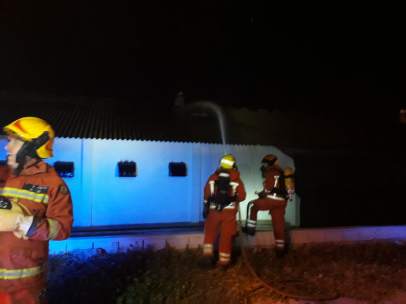 Los bomberos intentando extinguir el incendio