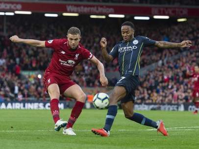 Henderson y Sterling pugnan por un balón en Anfield.