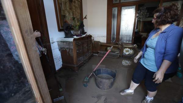 Mujer limpia su casa tras las lluvias en Sant Llorenç Mujer limpia su casa tras las lluvias en Sant Llorenç