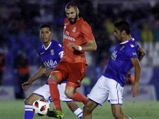 Benzema entre dos jugadores del Melilla.