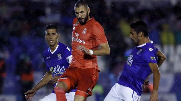Benzema entre dos jugadores del Melilla. Benzema entre dos jugadores del Melilla.