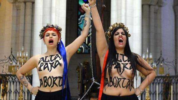 Dos activistas de Femen encadenadas a un crucifijo Dos activistas de Femen encadenadas a un crucifijo