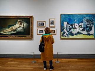 Una persona observa las obras " La maja desnuda" (1785-1800), de Francisco de Goya, y el "Desnudo recostado" (1964), de Pablo Picasso, durante la presentación de la exposición "Museo del Prado 1819-2019. Un lugar de memoria"