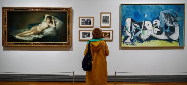 Una persona observa las obras " La maja desnuda" (1785-1800), de Francisco de Goya, y el "Desnudo recostado" (1964), de Pablo Picasso, durante la presentación de la exposición "Museo del Prado 1819-2019. Un lugar de memoria"