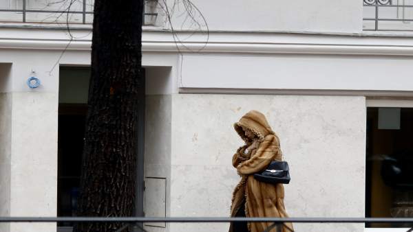Una mujer camina por la calle un día de invierno Una mujer camina por la calle un día de invierno