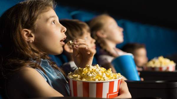 Niños comiendo palomitas en el cine Niños comiendo palomitas en el cine