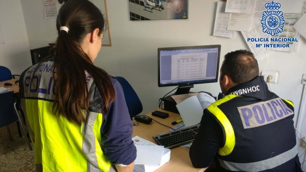 Agentes de la Policía Nacional examinan documentación del caso Agentes de la Policía Nacional examinan documentación del caso