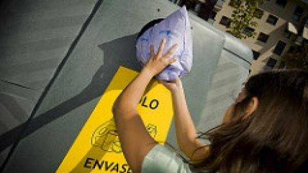 Ciudadano metiendo envases en contenedor amarillo Ciudadano metiendo envases en contenedor amarillo