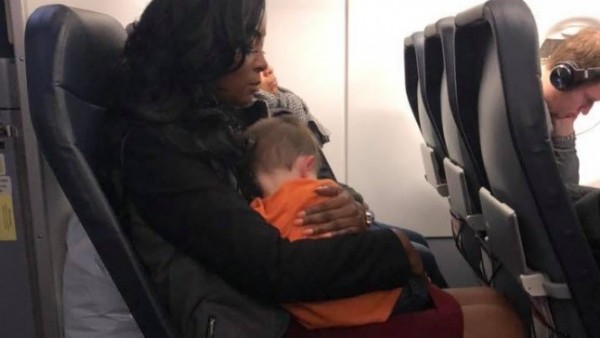 Una mujer carga al hijo de Becca Kinsey Una mujer carga al hijo de Becca Kinsey