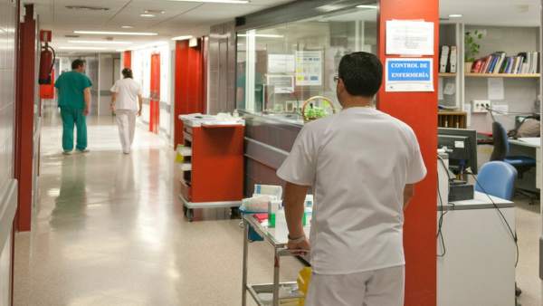 Un enfermero lleva un carrito de medicamentos Un enfermero lleva un carrito de medicamentos