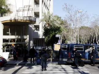 Agentes de la Policía Nacional descargando maletas de los furgones policiales delante de un hotel de Salou (Tarragona).