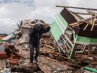 Hombre recoge pertenencia entre escombros del tsunami
