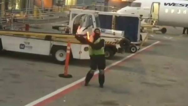 Un operario del aeropuerto bailando Un operario del aeropuerto bailando