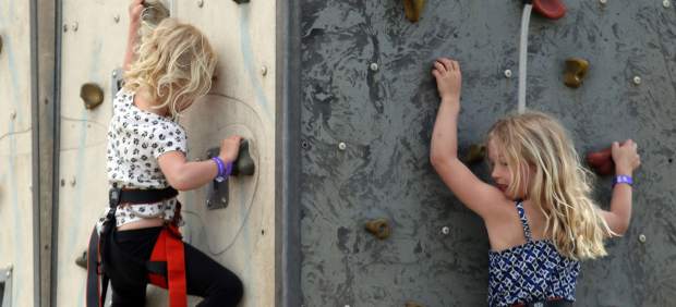 Dos niñas escalan en un rocódromo