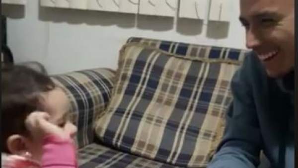 Una niña de dos años intenta hablar con su padre sordo con señas Una niña de dos años intenta hablar con su padre sordo con señas