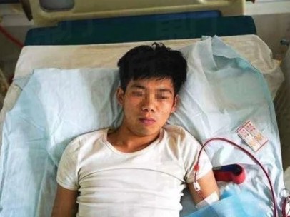El joven Xiao Wang en su cama con su máquina de diálisis