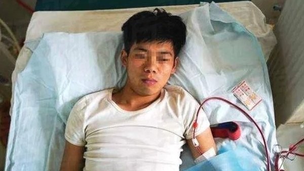 El joven Xiao Wang en su cama con su máquina de diálisis El joven Xiao Wang en su cama con su máquina de diálisis