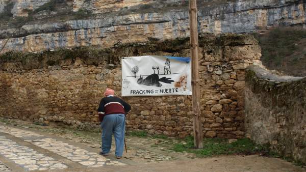 Hombre camina junto a cartel contra el fracking Hombre camina junto a cartel contra el fracking