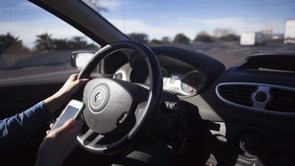 Conductor con teléfono móvil, conducción, tráfico, seguridad vial Conductor con teléfono móvil, conducción, tráfico, seguridad vial