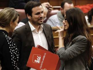 La nueva diputada de Unidos Podemos Sol Sánchez (d), sustituta de Íñigo Errejón que renunció ayer a su acta de diputado, acompañada por el líder de IU, Alberto Garzón (i), saluda a varios miembros de la formación a su llegada al pleno celebrado hoy en el Congreso