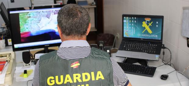 Un agente de la Guardia Civil inspecciona archivos en un ordenador
