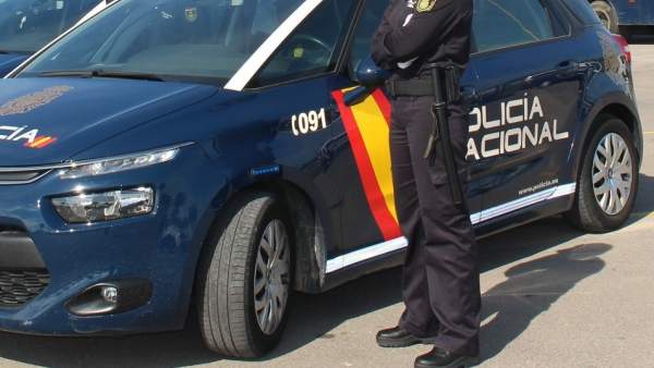 Agente y coche de la Policía Nacional Agente y coche de la Policía Nacional