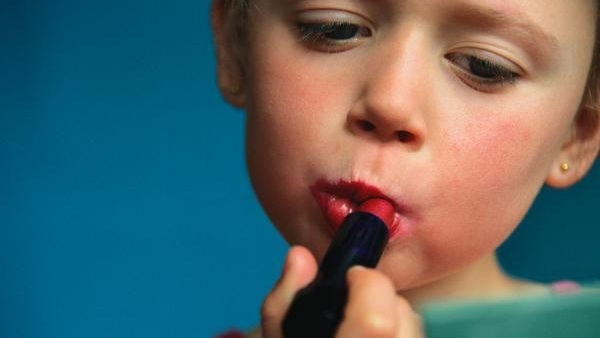 Niña aplicándose un pintalabios Niña aplicándose un pintalabios