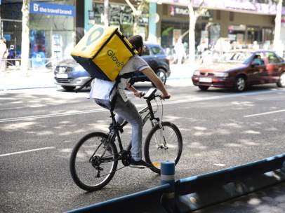 Trabajador de la empresa Glovo montando en bicicleta por Madrid.