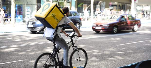 Trabajador de la empresa Glovo montando en bicicleta.
