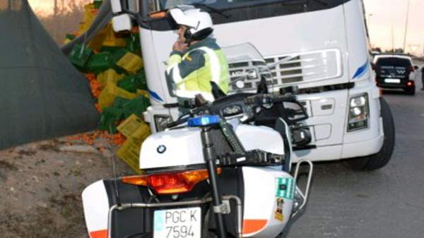 Agente de la Guardia Civil junto a la carga y el camión siniestrado Agente de la Guardia Civil junto a la carga y el camión siniestrado
