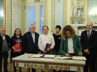 La ministra de Política Territorial, Meritxell Batet, firma con los representantes sindicales, en la sede del Ministerio,