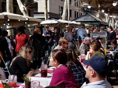 Terrazas de La Rambla, en Ciutat Vella, llenas de clientes en un día soleado en Barcelona.
