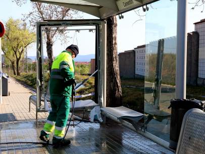 Un operario limpiando la parada de autobús de Sabadell de delante del cementerio tras el accidente mortal.