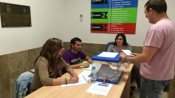 Una persona deposita un voto en las urnas Una persona deposita un voto en las urnas